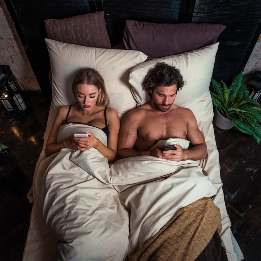 coppia a letto con telefoni problemi di intimita